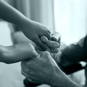 Female doctor and senior man holding hands in nursing home Cropped image of female doctor and senior man holding hands in nursing home