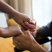 Female doctor and senior man holding hands in nursing home Cropped image of female doctor and senior man holding hands in nursing home